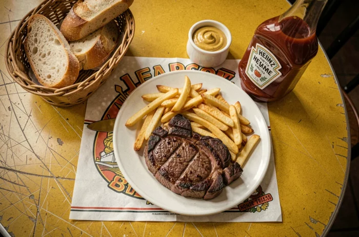 Plat emblématique steak-frites sur une table en formica d'un ancien restaurant populaire français des années 80